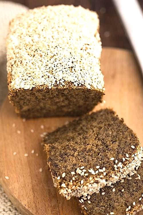 Un pain maison fait avec des graines de chia, sur une planche à découper en bois.