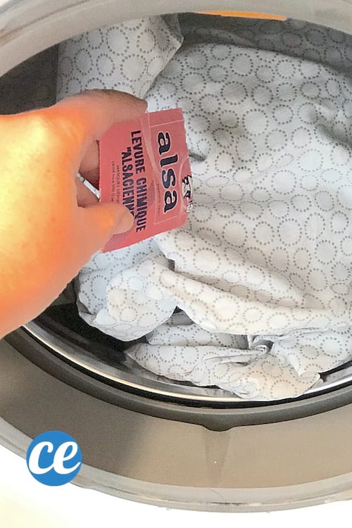 Un sachet de levure chimique versé dans la machine à laver pour blanchir les vêtements