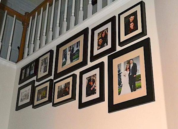 Un mur de cadres photos dans un escalier