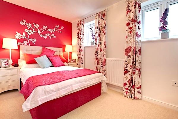 Un mur de la chambre peint en rouge pour embellir la pièce