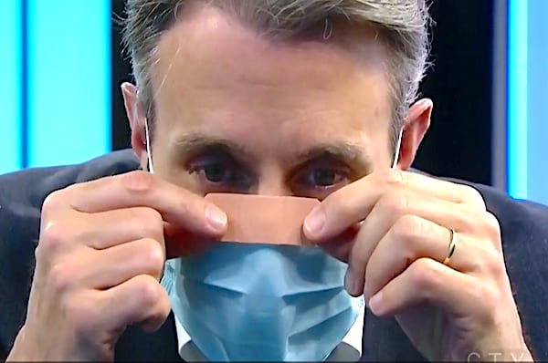 Une homme qui colle un pansement sur le masque contre la buée des lunettes