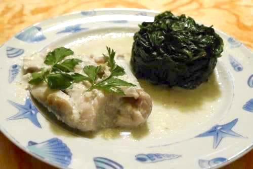 une assiette de poisson blanc préparé au lait de coco