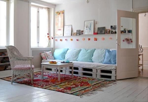 Espace détente avec plusieurs siège en long fait avec plusieurs palettes en dessous