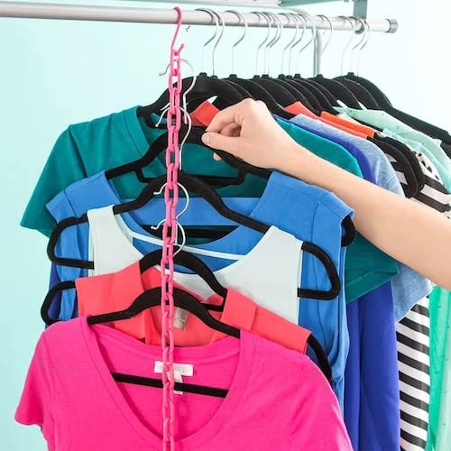 Chaîne rose qui sert de maintient pour des cintres de vêtements