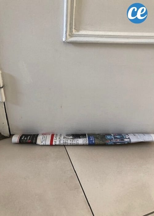 papier journal sous une porte courant d'air