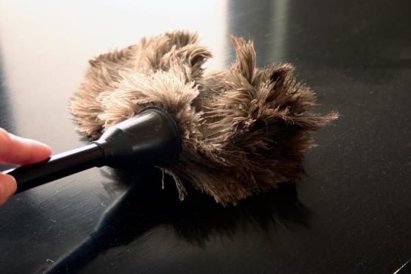 Un plumeau noir qui faire la poussière sur les meubles de la cuisine