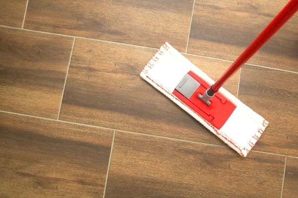 Un balai serpillère sur le sol en carrelage pour nettoyer la cuisine