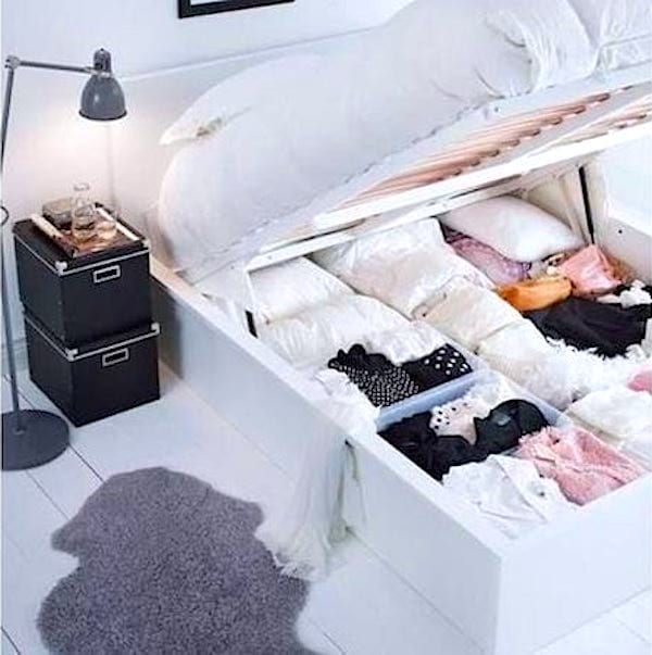 Un petit dressing sous un lit de couleur blanche