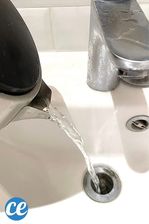 De l'eau bouillante versée dans le lavabo avec une bouilloire