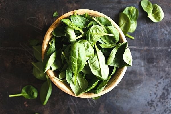 feuille de basilic dans un bol en bois