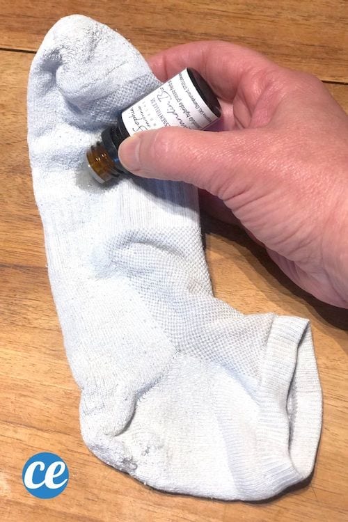 Quelques gouttes d'huile essentielles sont versées sur une chaussette blanche.