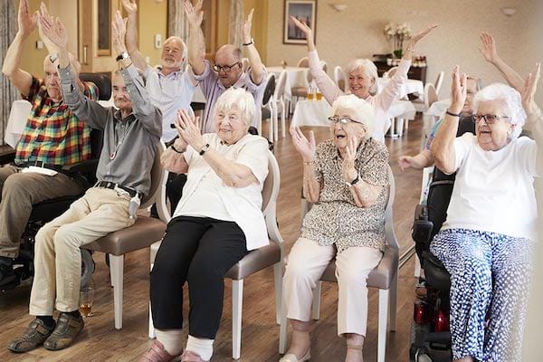 Des personnes âgées dans une Ehpad qui lèvent les mains