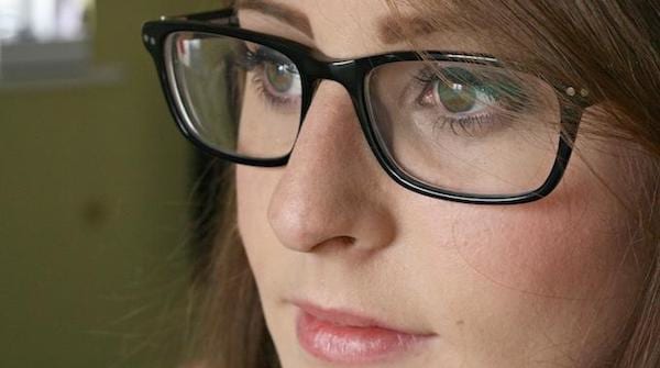 Une jeune femme qui porte des lunettes avec une monture noire