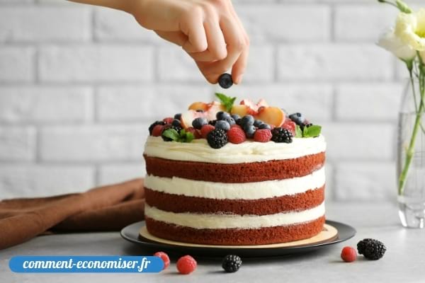 Une main qui décore un gâteau fait maison.