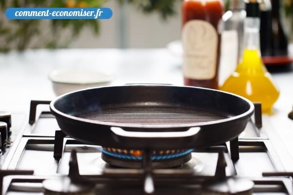 Une poêle en train de chauffer sur la plaque de cuisson d'une cuisine.