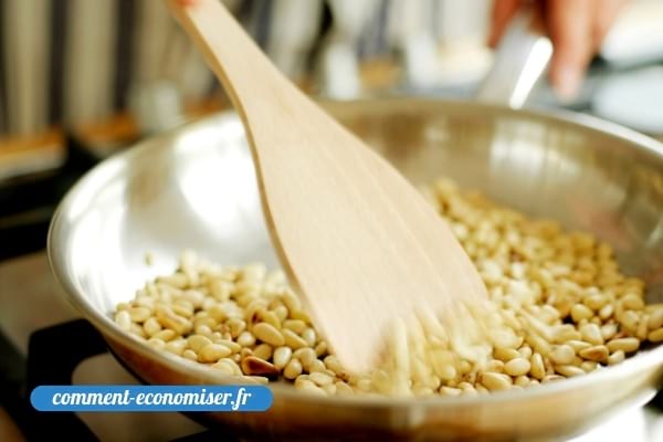 Des pignons qui grillent dans une poêle en acier.