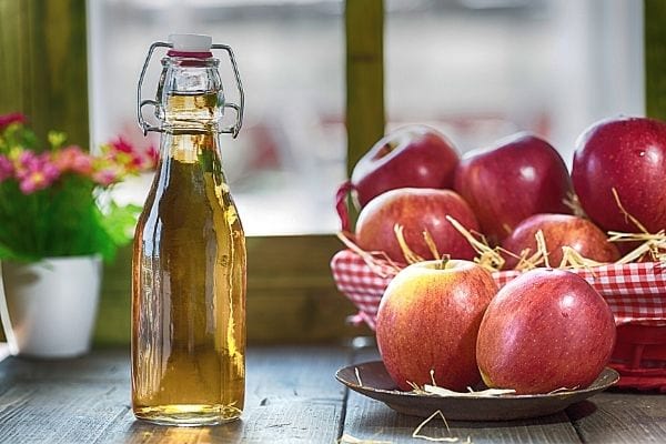 bouteille de vinaigre de cidre et pomme rouges