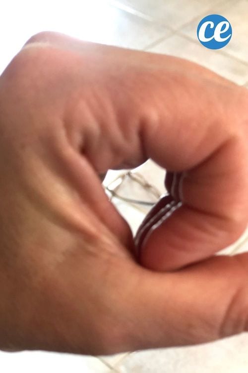 Une main qui forme un rond pour voir une paire de lunettes sur le sol