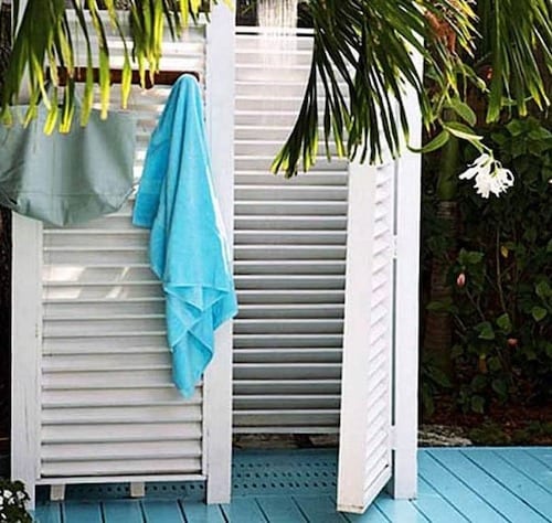 Douche extérieure avec des volets blancs