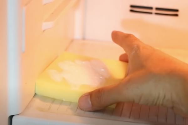 Éponge dans un frigo saupoudrée de bicarbonate utilisée pour enlever les mauvaises odeurs