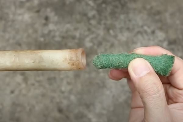 Petit morceau d'éponge vert utilisée pour nettoyer un tuyau d'arrosage