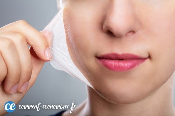 Une femme qui enlève un masque peeling de son visage.