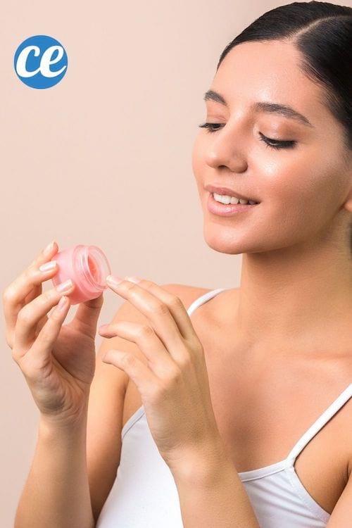 Une femme brune fait un gommage pour avoir des lèvres pulpeuses