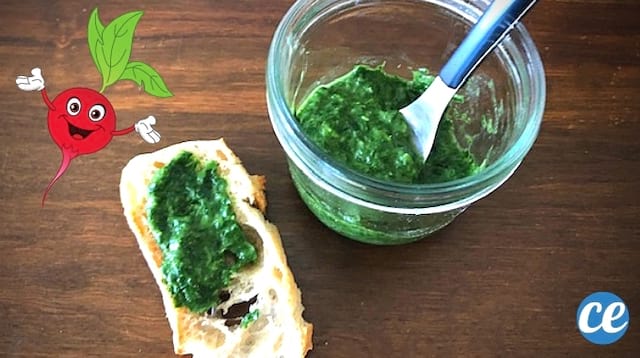Un pot en verre avec du pesto maison dedans et une tartine de pesto sur une table en bois