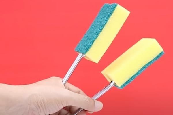 Deux éponges dans une pince à salade qui sont utilisées afin de nettoyer les fenêtres persiennes et les stores