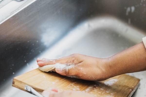 Planche à découper dans un évier avec une éponge