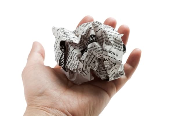 Une boule de papier journal dans une main pour nettoyer parois vitrées de douche