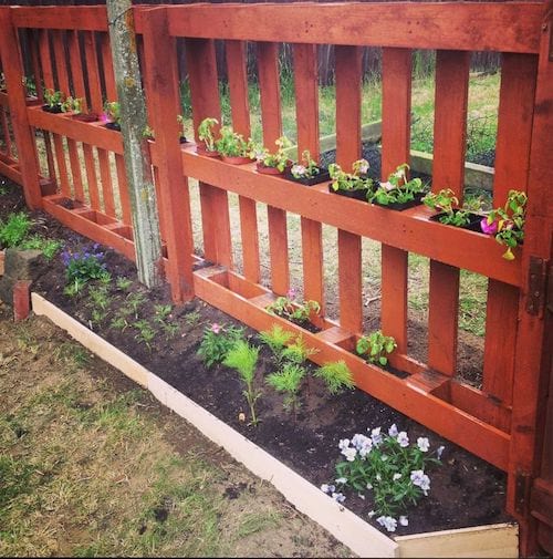 A DIY fence with a pretty flower bed.