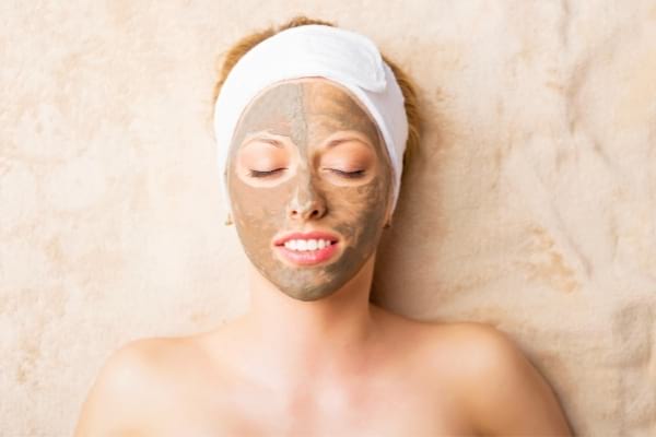 Une femme qui a mis de l'argile sur le visage pour profiter de ses bienfaits