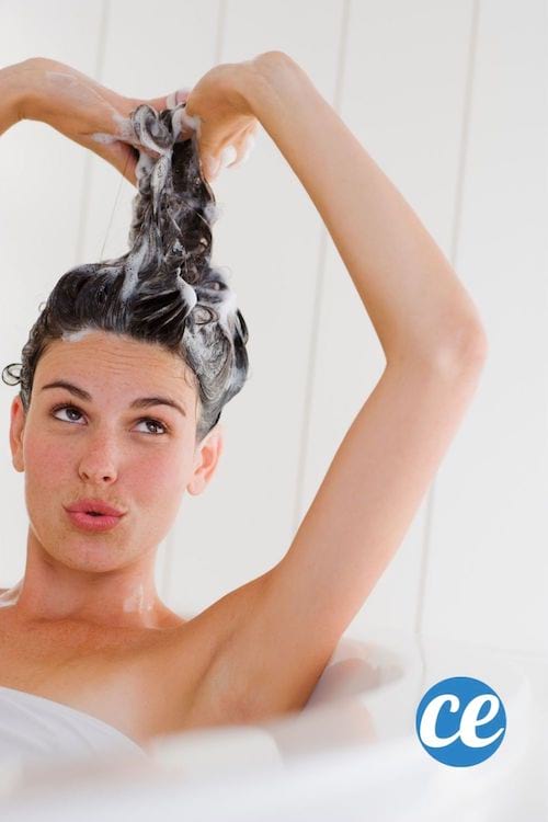 Une jeune femme lave ses cheveux en faisant une banane