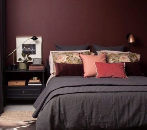 La couleur de la peinture murale de cette chambre est lie-de-vin