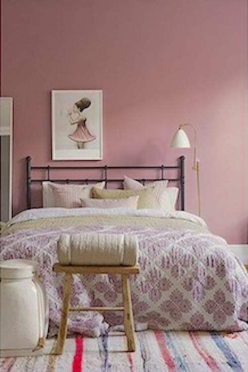 La couleur de la peinture murale de cette chambre est le rose