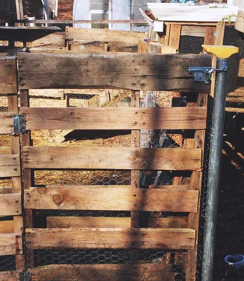 A wooden pallet fence, with a real hinged door.