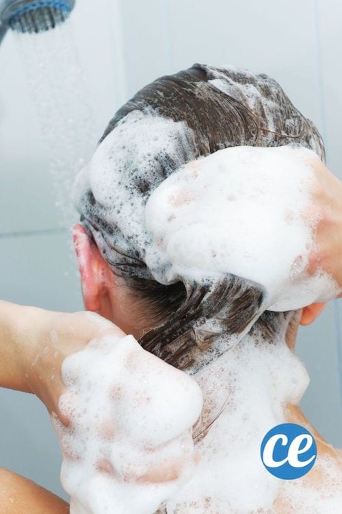Une femme met du shampoing sur tous ses cheveux