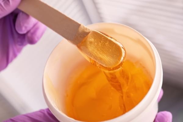 Un mélange au sucre dans une coupelle pour s'épiler