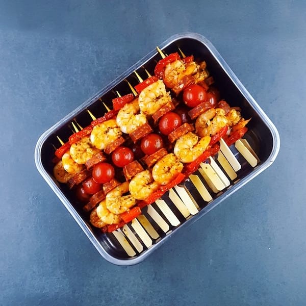 Brochettes de crevettes, chorizo et tomates dans un plat