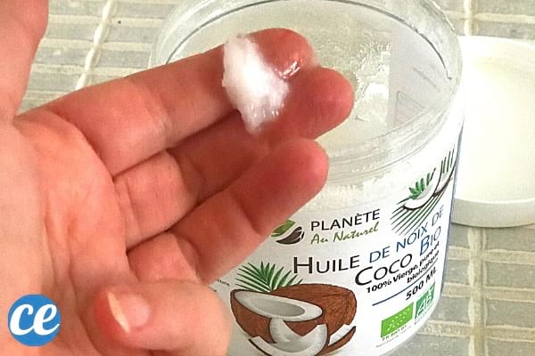 Une main qui prend de l'huile de coco pour bronzer plus rapidement