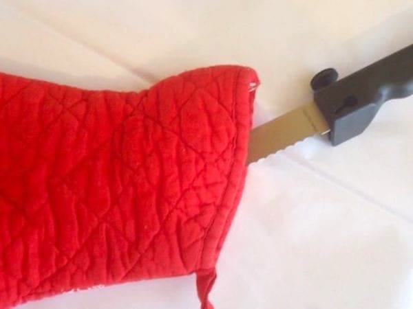 Couteau dans un gant de cuisine rouge