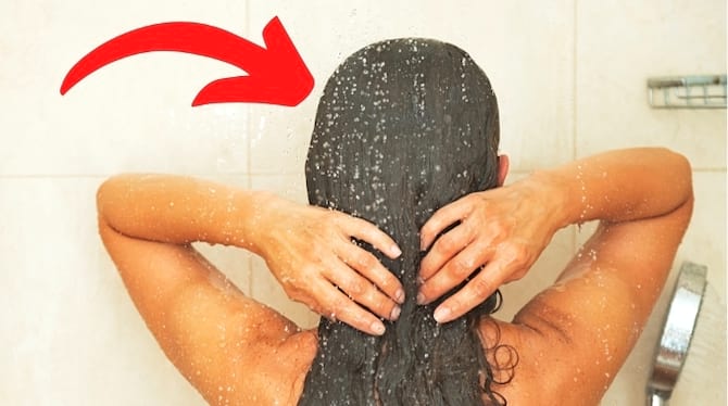 Une femme qui ne se mouille passez les cheveux avant le shampoing