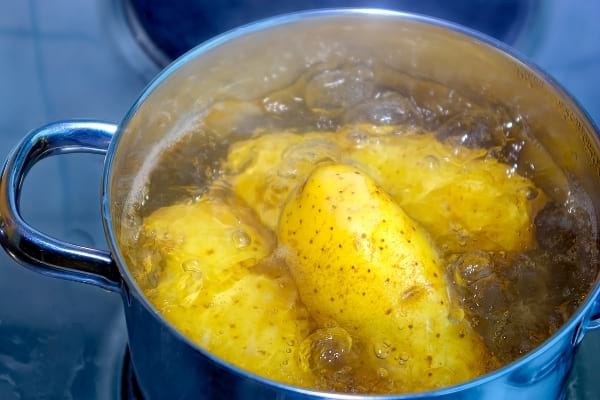 Des pommes de terre cuite à l'eau dans une casserole d'eau bouillante
