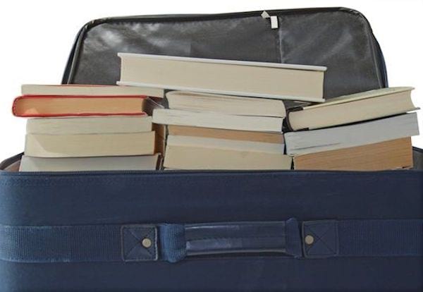 Plusieurs livres empilés dans une valise