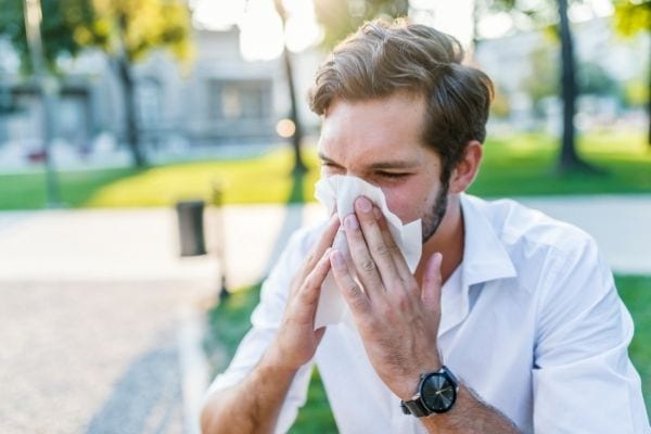 Un homme se mouche à cause des allergies au pollen