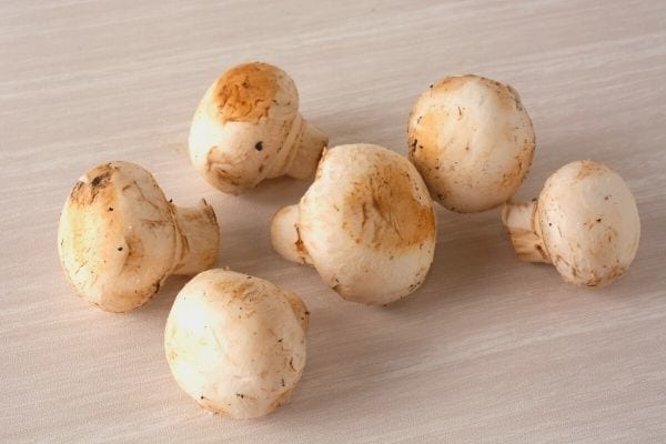 Des champignons de paris sur une table plein de vitamine D