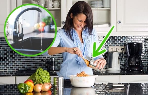 Une femme qui est en train d'ouvrir une boîte de conserve après l'avoir lavée