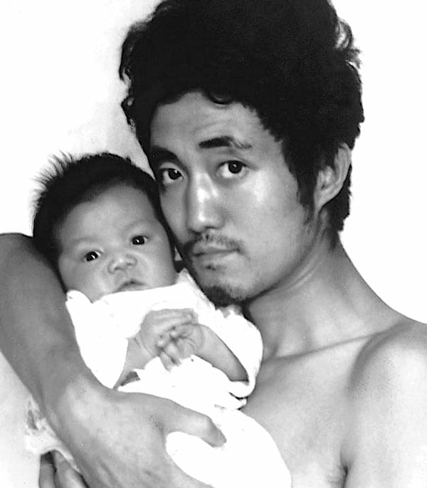 Photo en noir et blanc d'un père et de son bébé en 1986