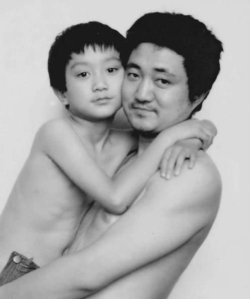 Photo en noir et blanc d'un père et de son fils torse-nu en 1994